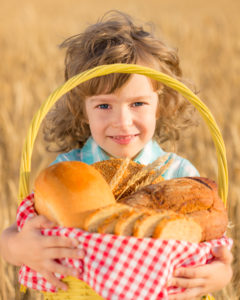 Young girl holding basket of whole grain breads